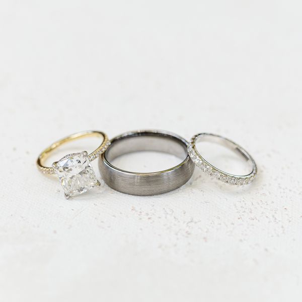 cushion-cut diamond engagement ring with a gold band; silver wedding band; silver, pave diamond wedding band