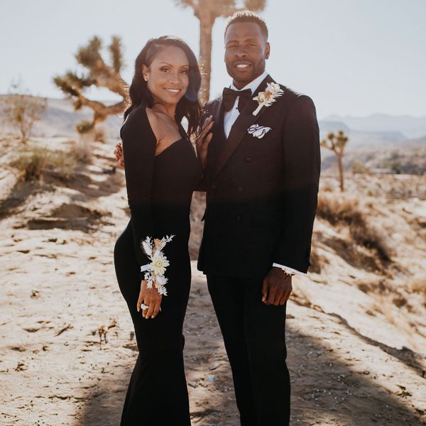 Woman wearing an all-black dress posing next to man wearing a tuxedo 
