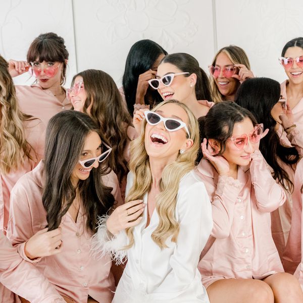 bride and her bridesmaids laughing and posing for photos in pajamas and sunglasses
