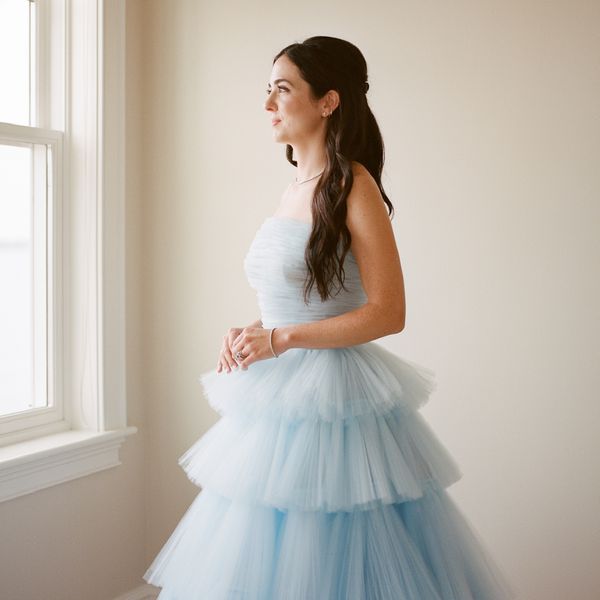 bride wearing a blue tulle wedding dress looking out the window