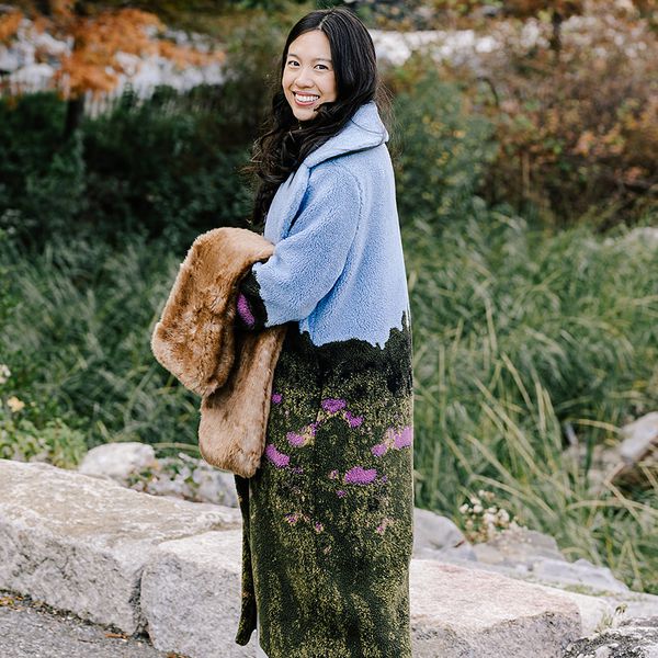 Woman wearing a fur trench coat with a garden landscape design