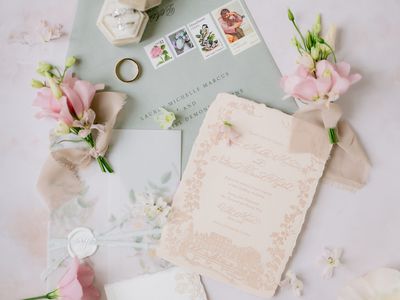 Vintage Pastel Wedding Invitations Next to Pink Flowers and Rings
