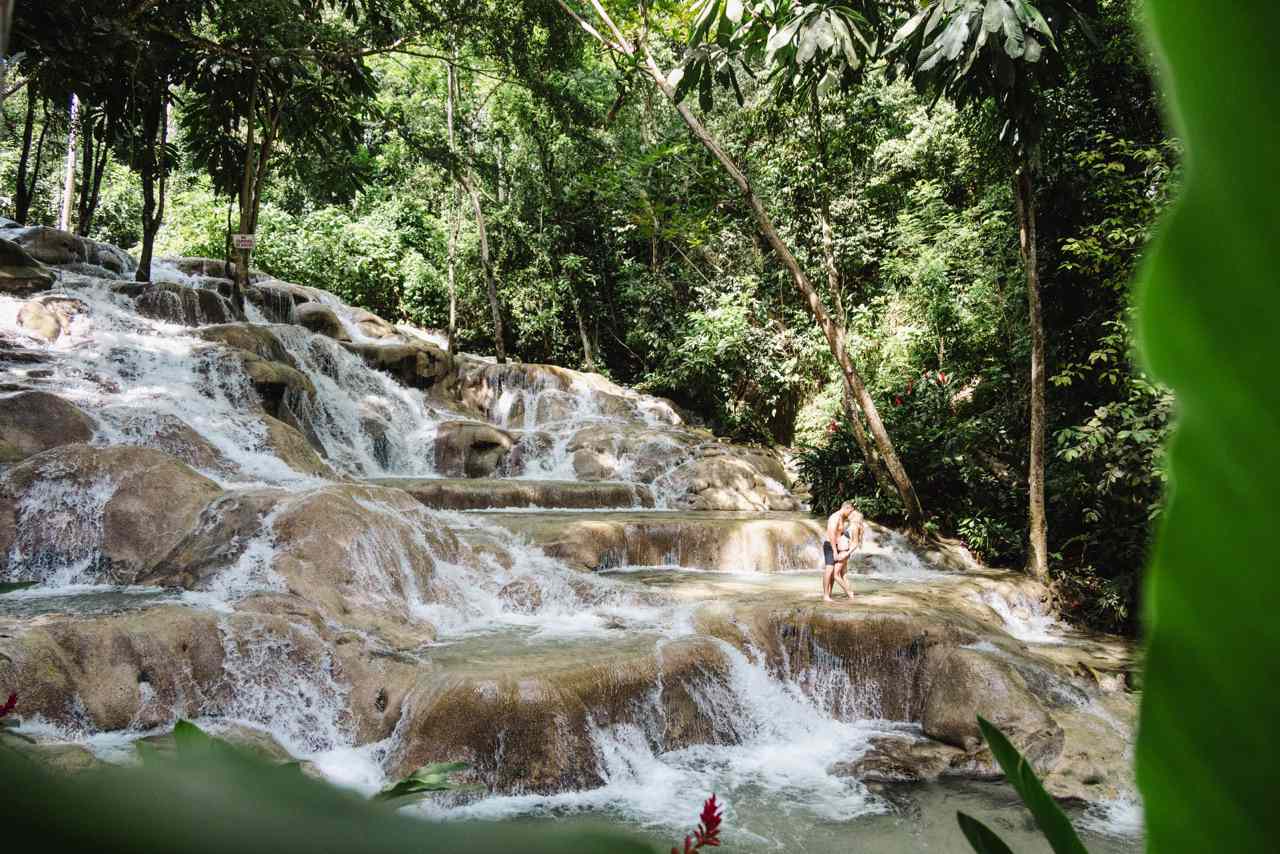Wedding Couple in Swimwear Kissing by Waterfall