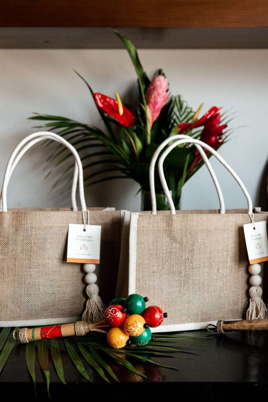 Wedding Tote Bags Next to Tropical Flowers and Colorful Handheld Instrument