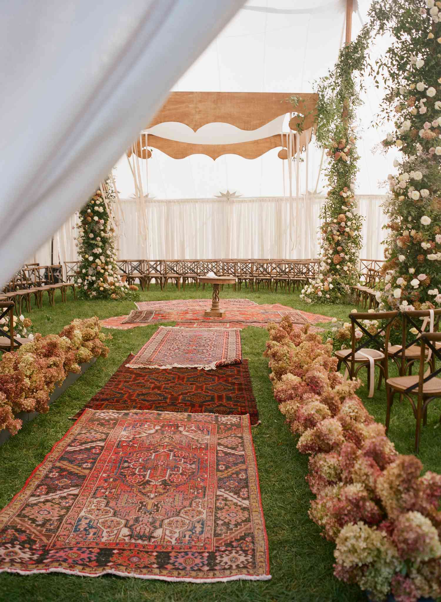 a suspended wooden chuppah under a tent