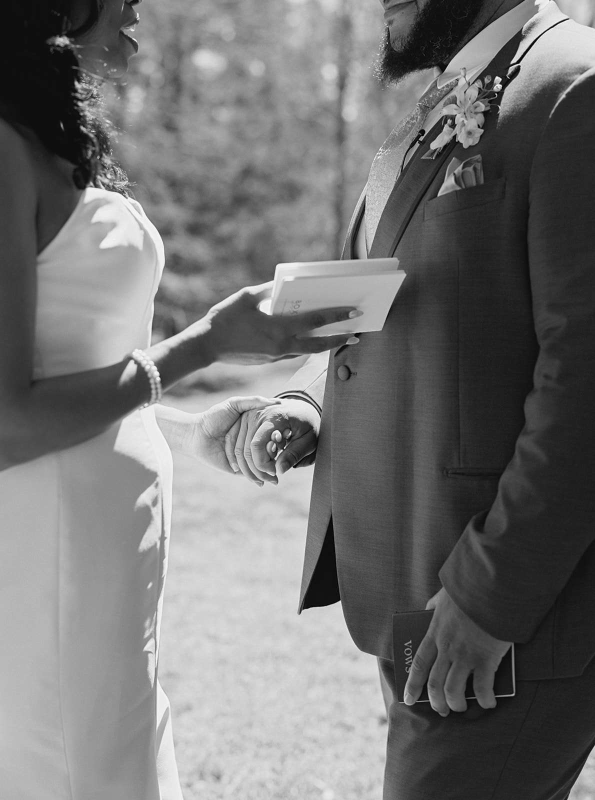 Black and White Close Up of Bride in Wedding Dress Reading Vows to Groom in Suit