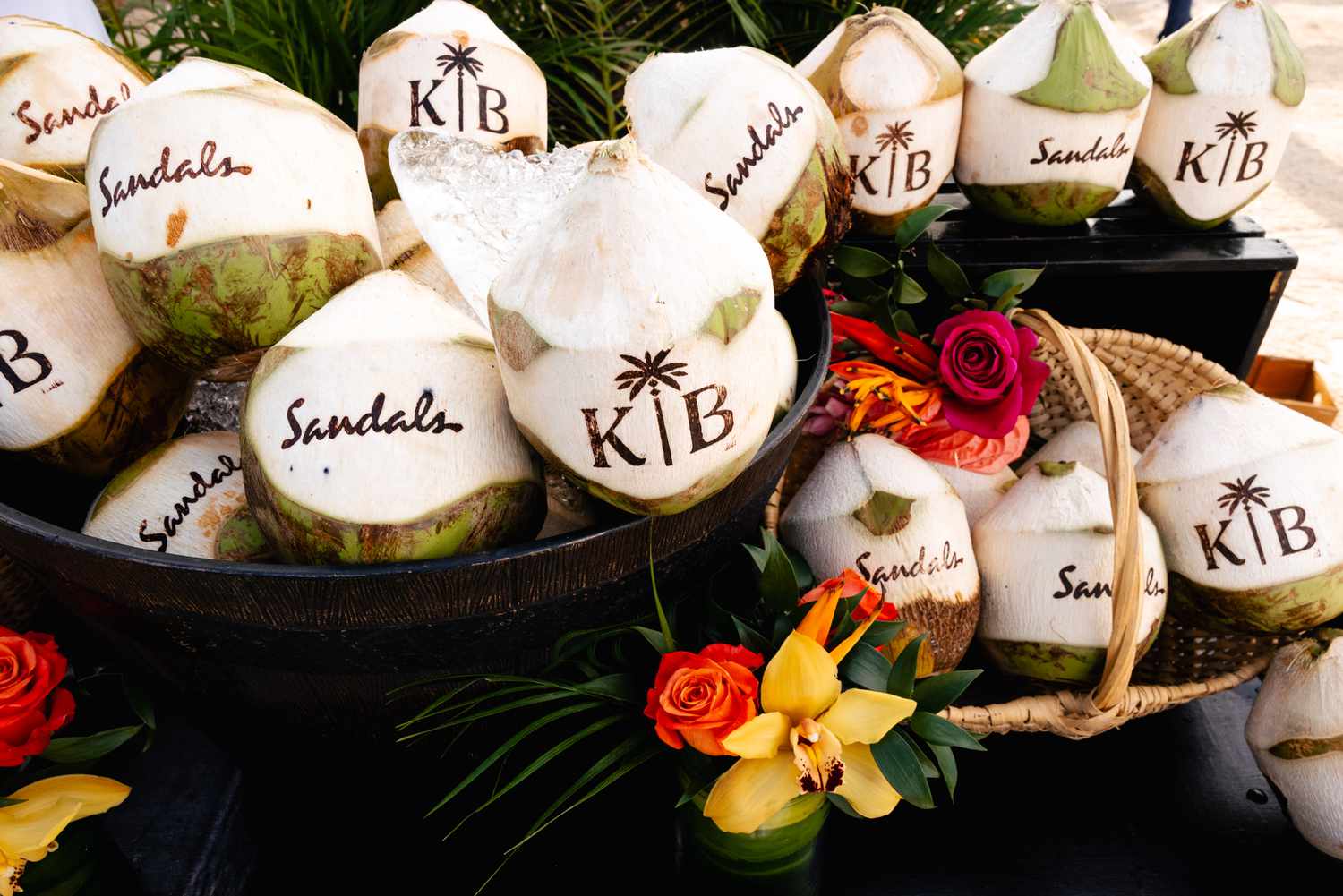 Custom Engraved Coconuts in Baskets Next to Flower Decor at Wedding