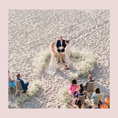 couple and officiant at a wedding ceremony on the beach.