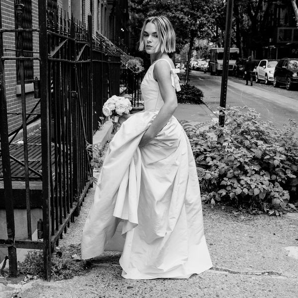 black and white photo of a bride posing outside in NY with her wedding dress and posy bridal bouquet