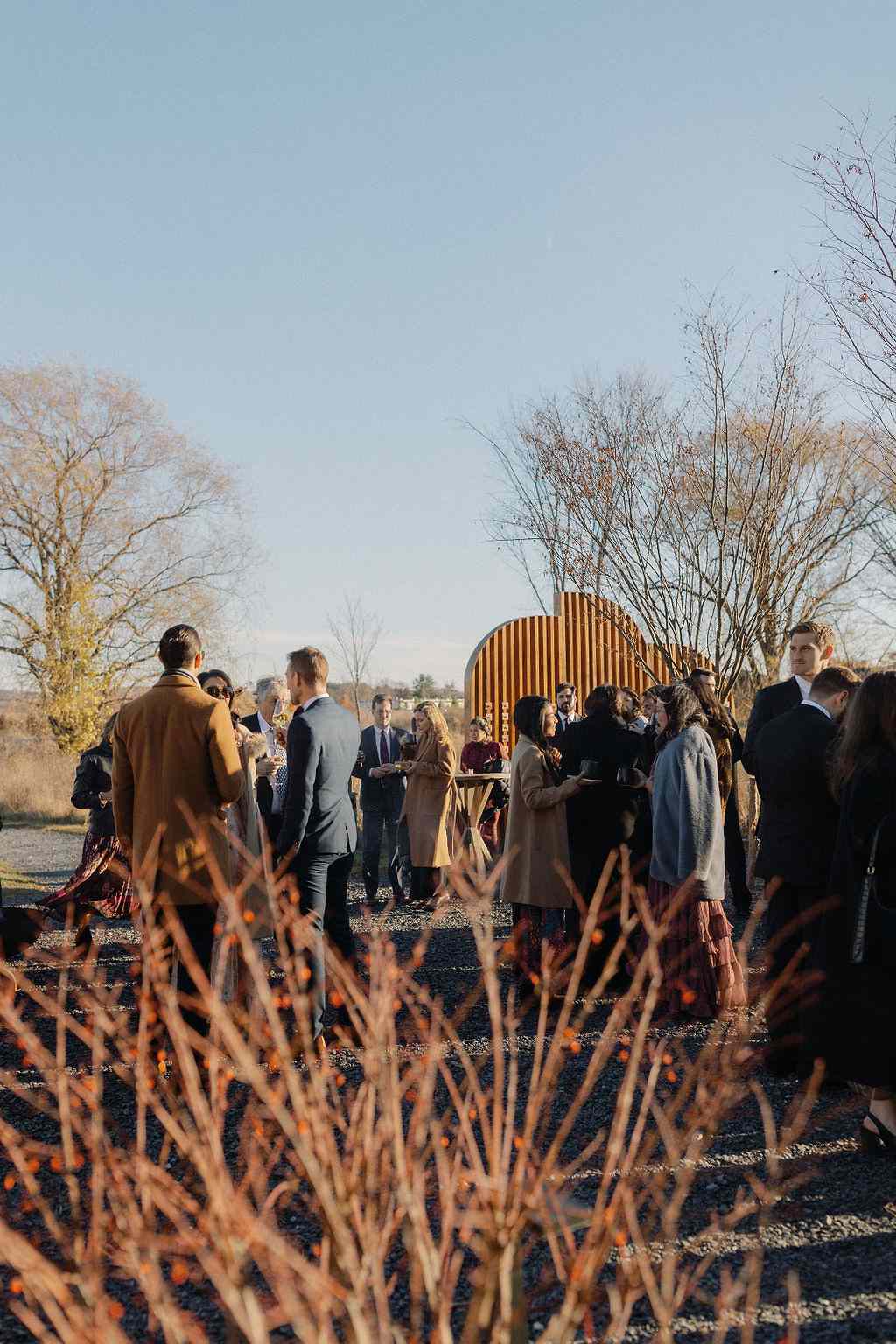 Wedding Guests in Formal Attire and Coats Before Wedding Ceremony