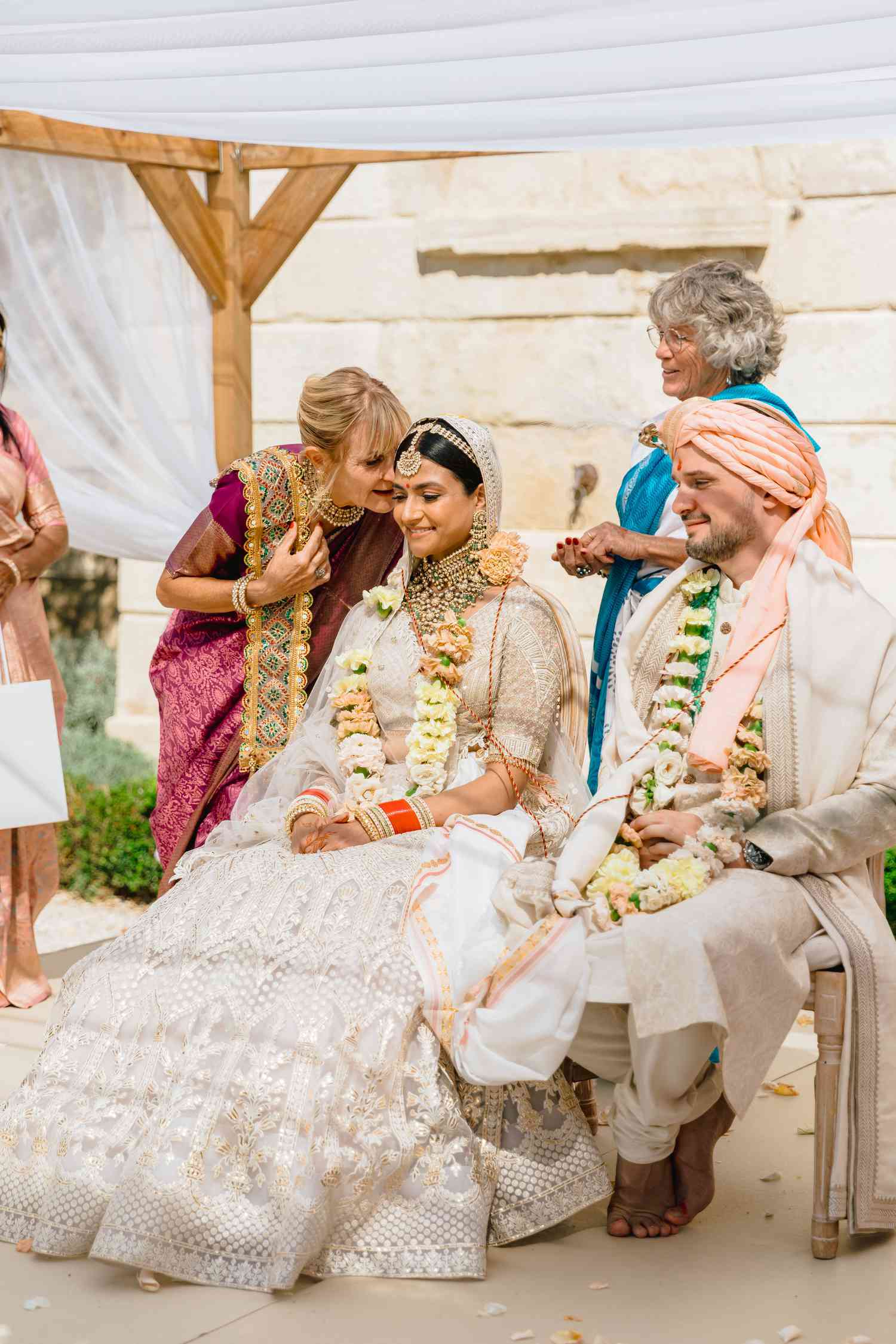 bride in traditional Indian wedding attire with groom and groom's parents