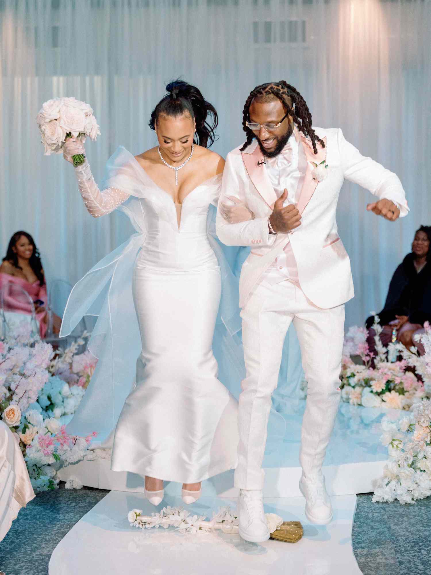 bride and groom jumping over wedding broom