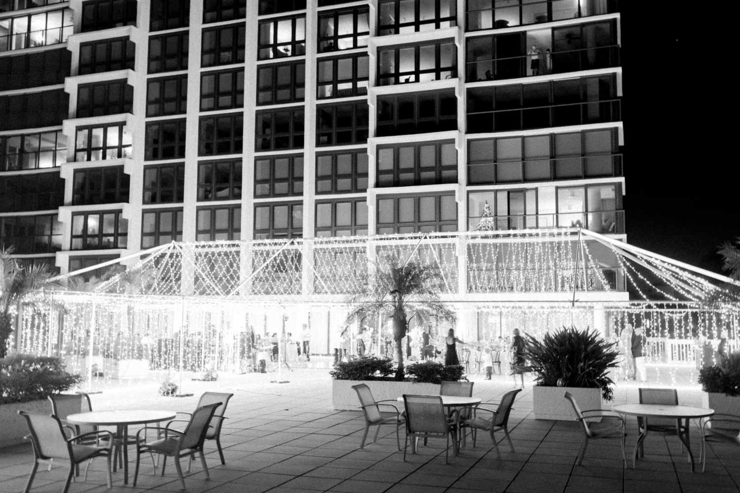 Black and White Image of Wedding Reception Venue Covered in String Lights