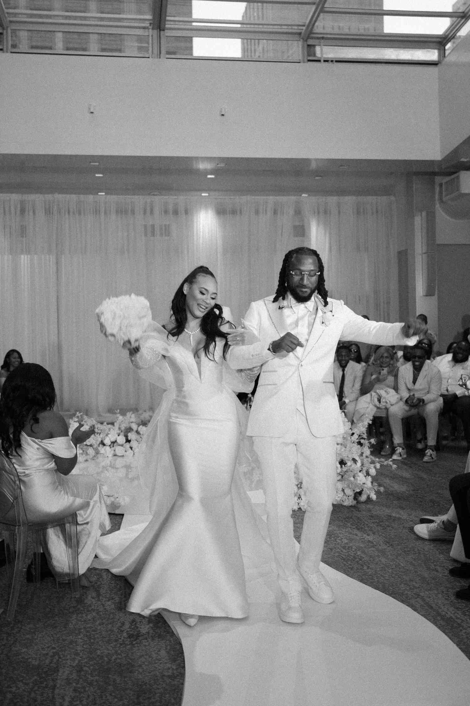black and white couple dancing down aisle