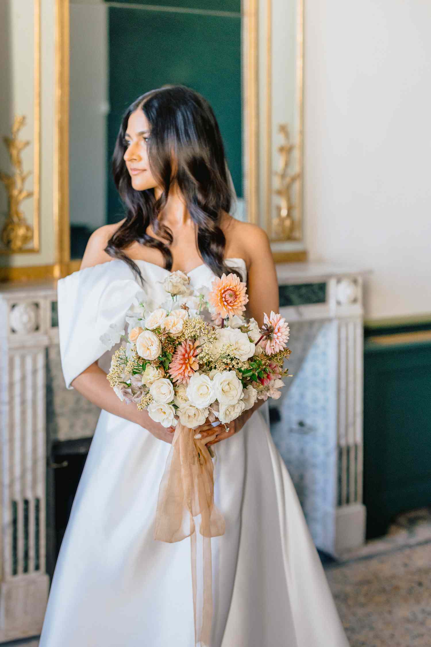 bride in white wedding dress holding bouquet of flowers