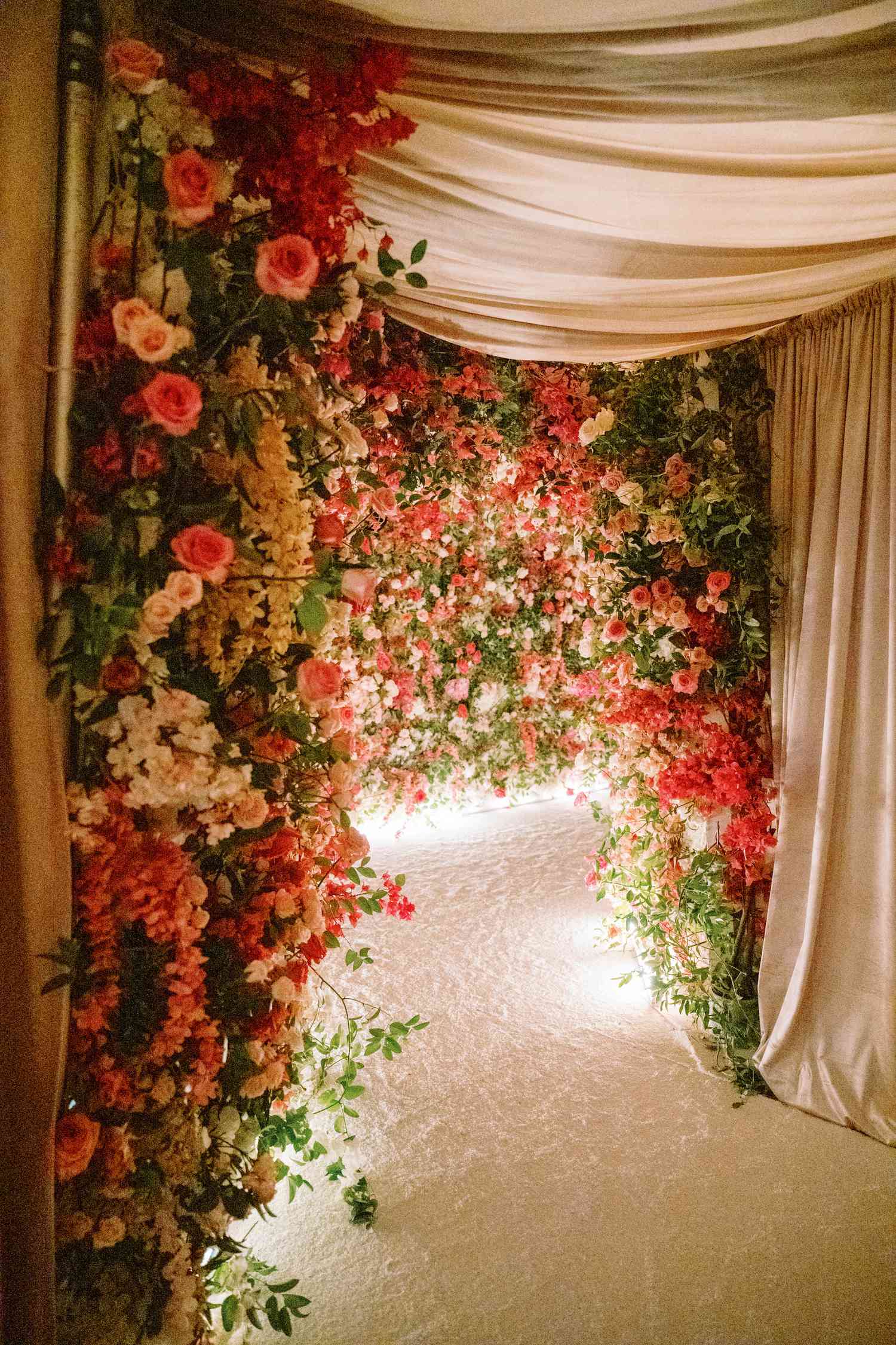 hallway cover in head to ceiling flowers with silk curtains draping from the ceiling