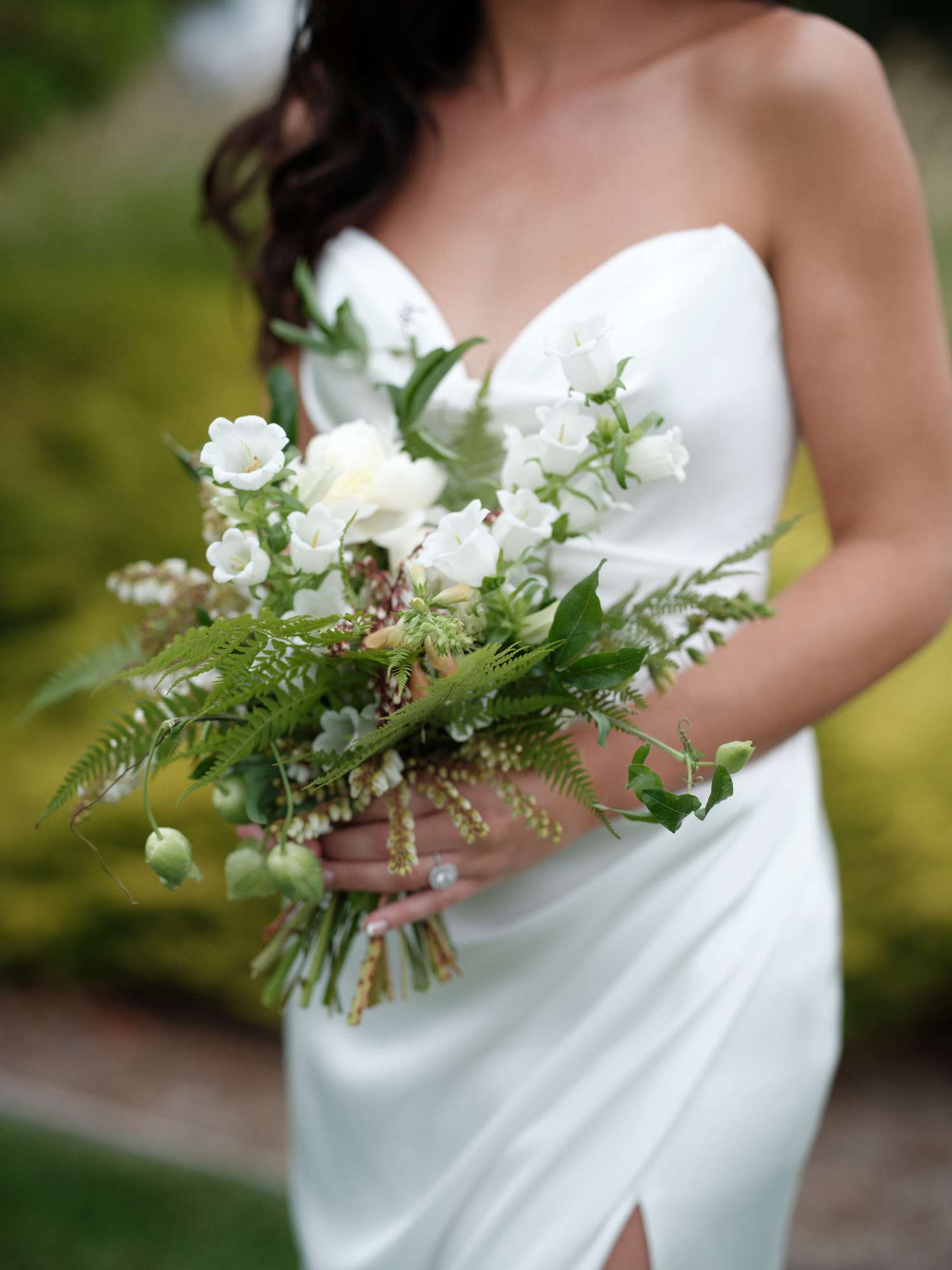 Close Up of Bride in Wedding Dress Holding White Bouquet