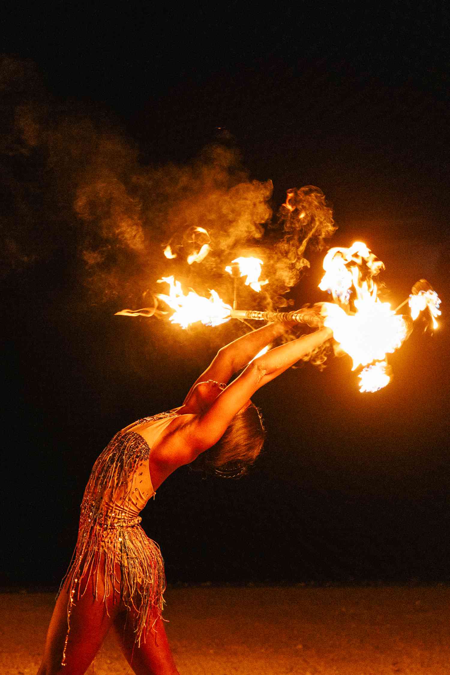 Woman in Leotard Dancing With Fire at Beach Reception