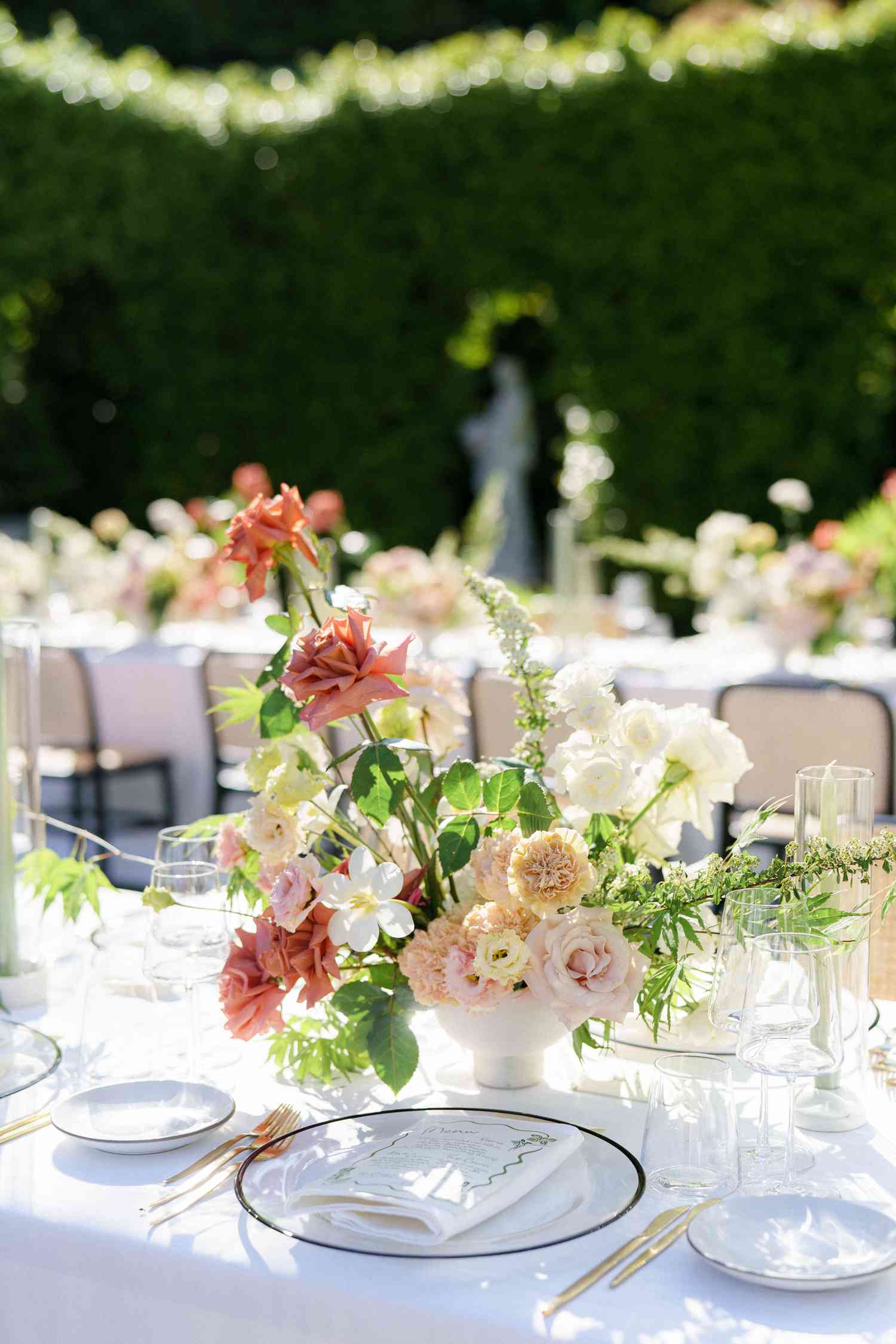 Wedding Reception Table with Floral Wedding Centerpiece with Roses, Carnations, and Greenery