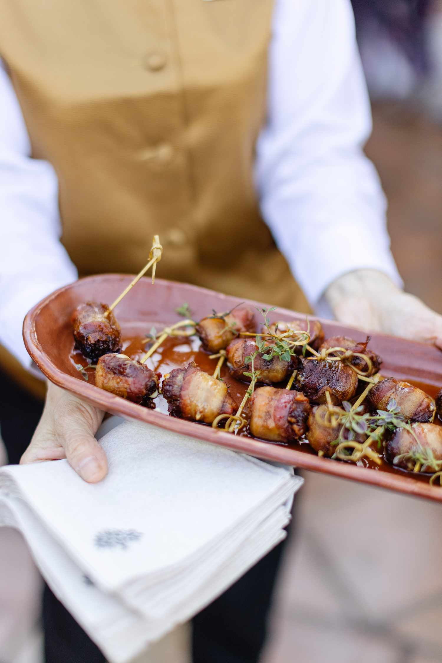 Bacon-Wrapped Dates Served on Brown Ceramic Tray During Wedding Cocktail Hour