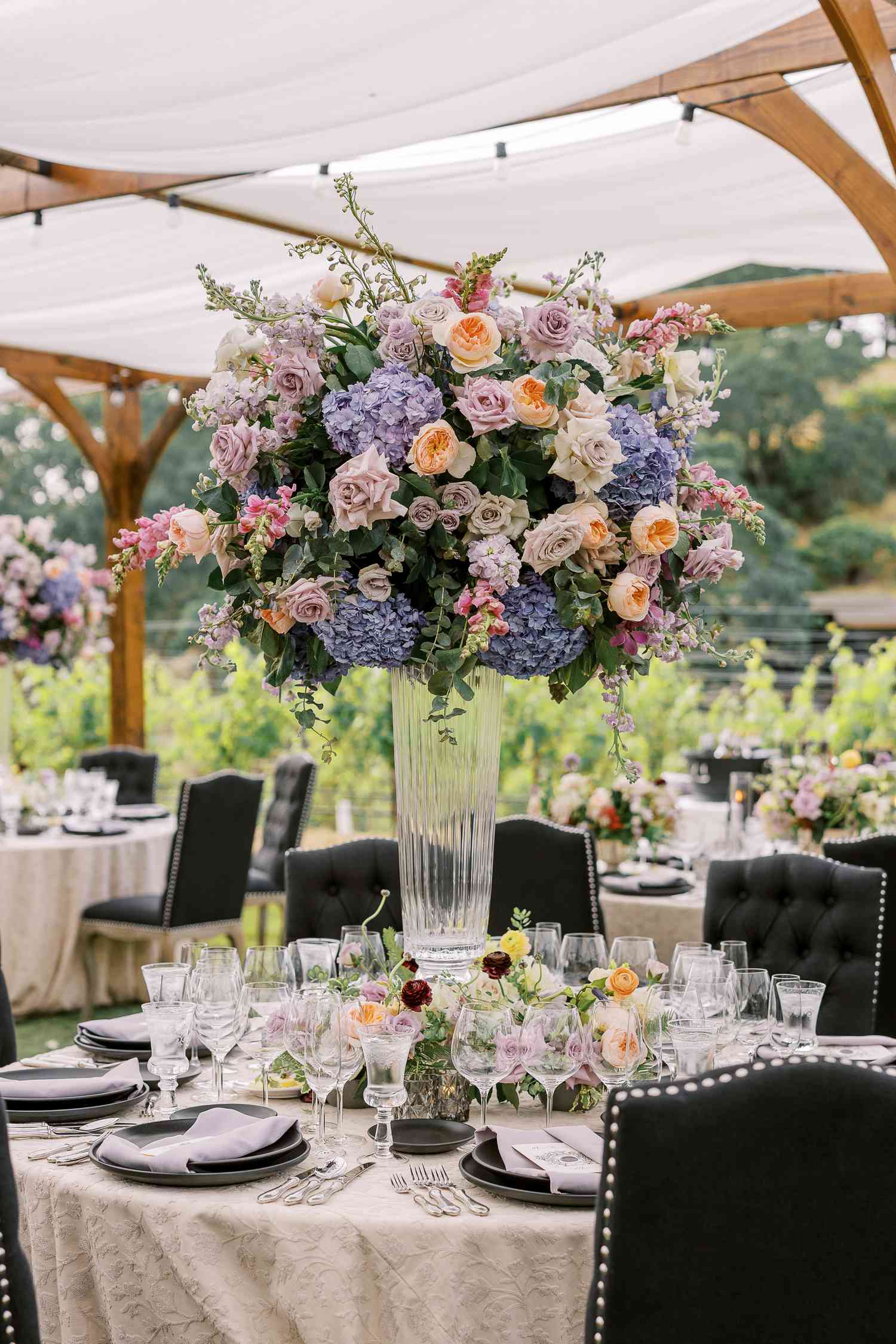 Tall, Lush Centerpiece of Pink and White Flowers Including Roses, Hydrangeas, Snapdragon, Stock, and Greenery on Round Reception Table