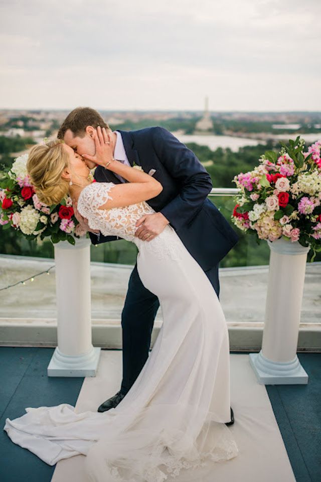 bride and groom kissing on rooftop