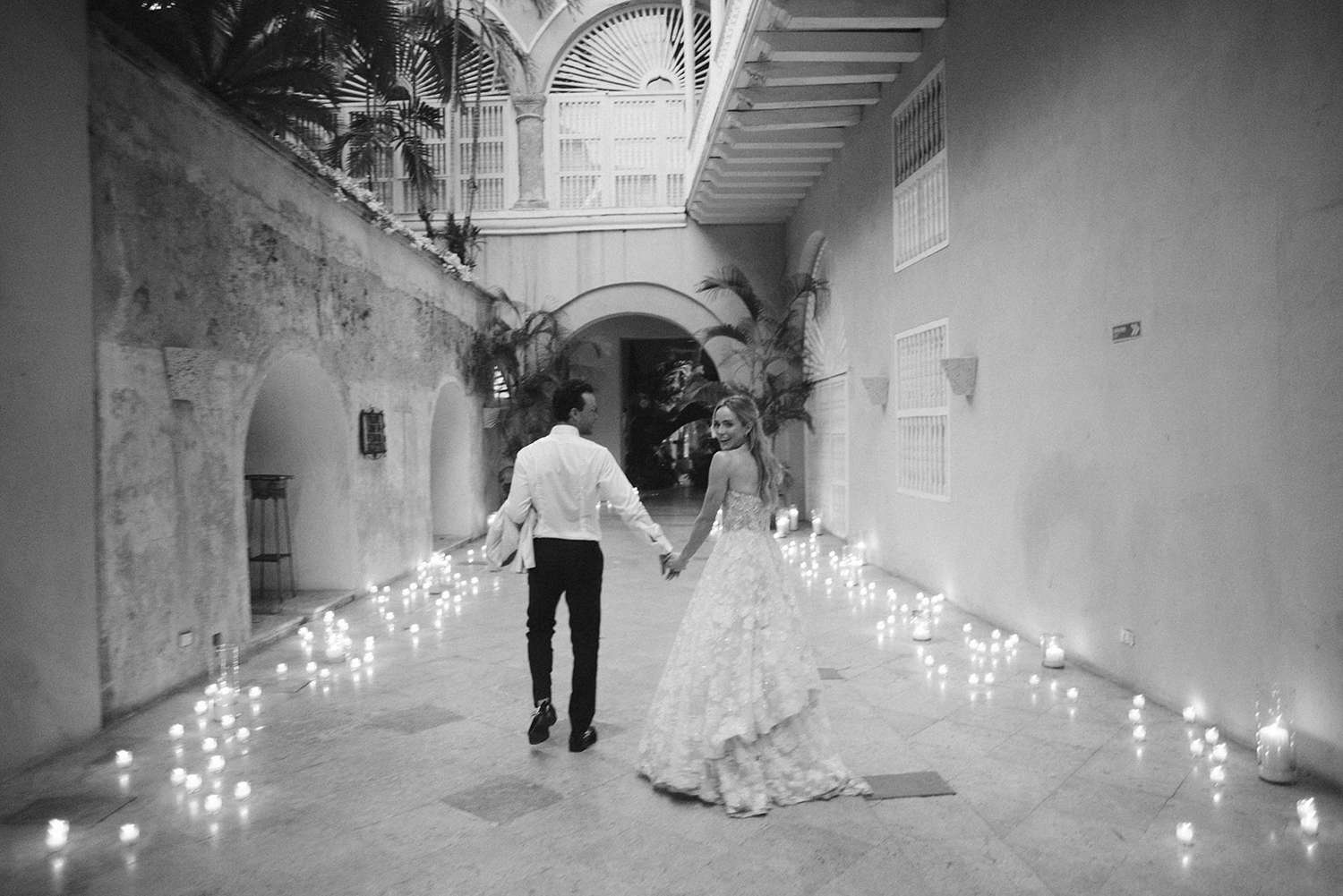 Bride and Groom Make Their Wedding Entrance By Walking Down a Path of Candles