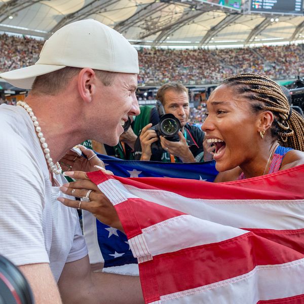 Emotional Tara Davis-Woodhall Wrapped in American Flag Reaching for Smiling Hunter Woodhall