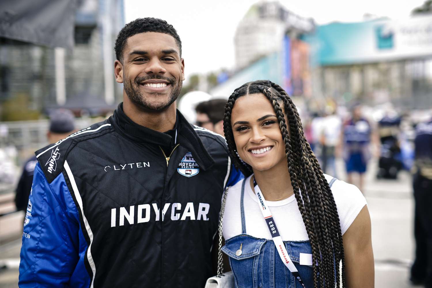 Andre Levrone Jr. in Race Car Outfit Posing With Sydney McLaughlin in Jean Overalls