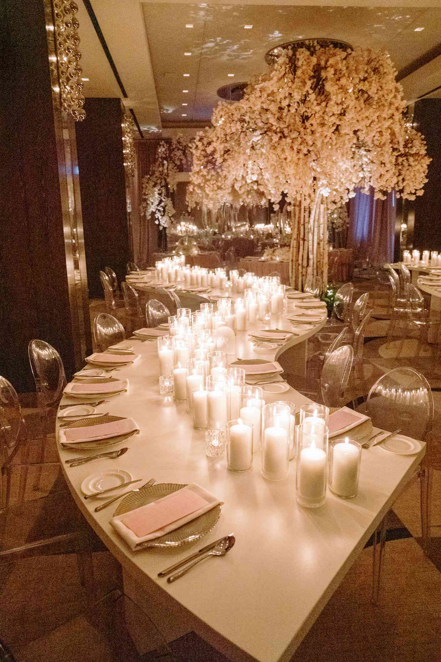 curve dining table with a lot of candles in the center