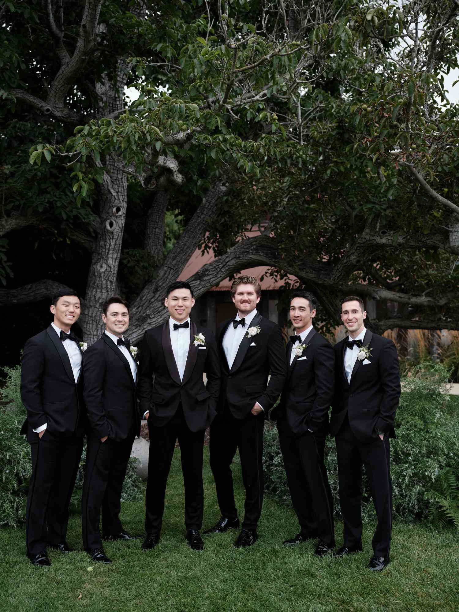 Groom in Black Tuxedo Posing With Groomsmen in Black Tuxedo