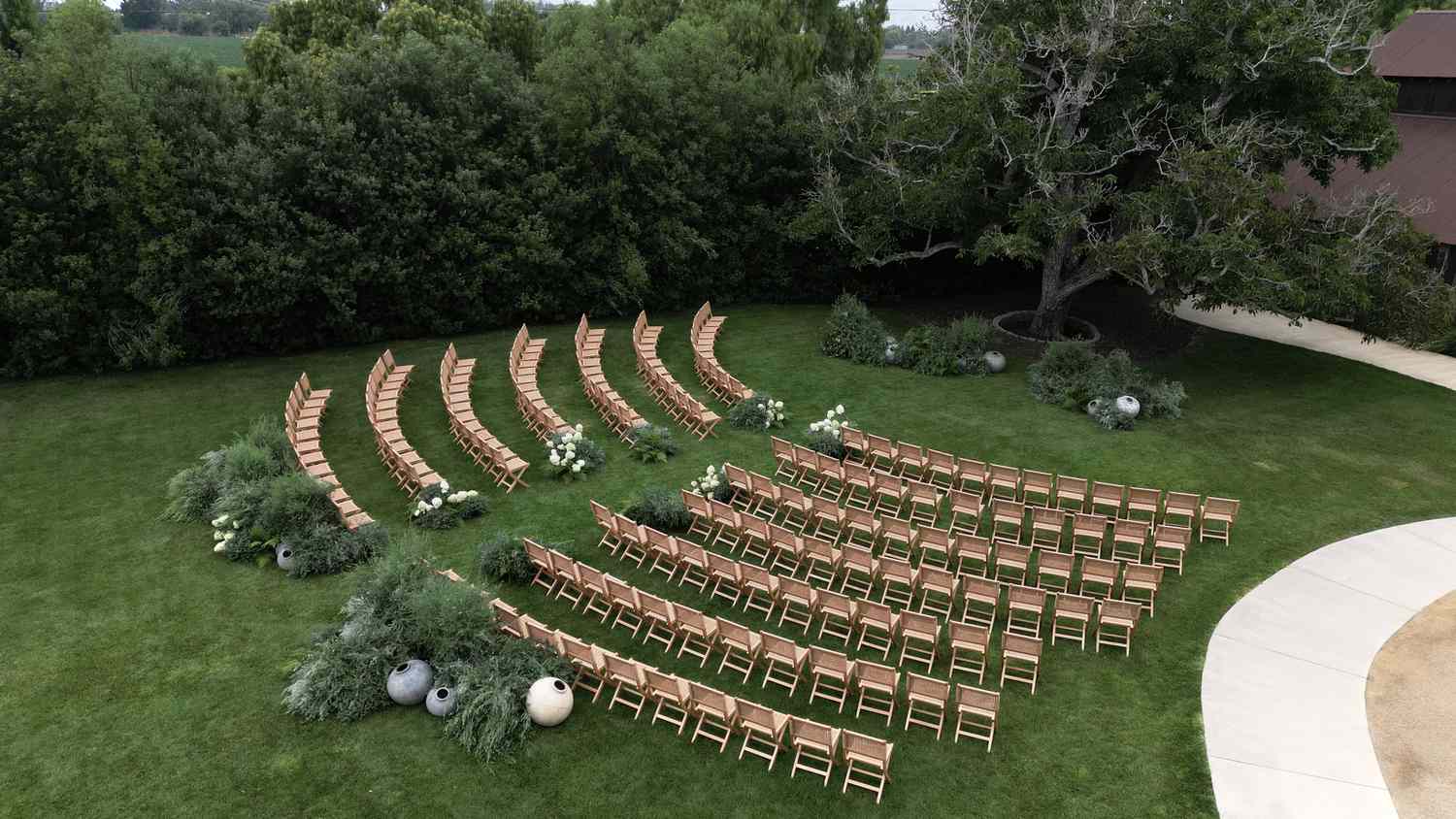 Wooden Chairs Arranged in Front of Altar With Large Tree and Plant Decor