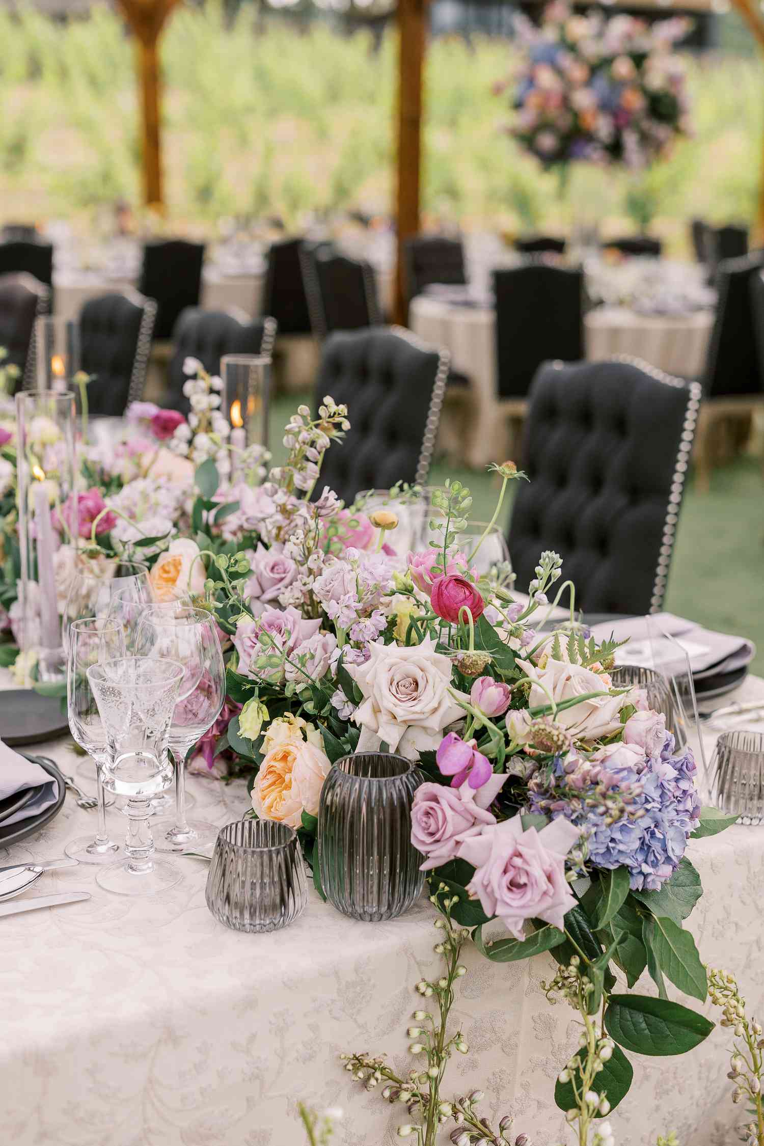 Purple Flower Decor on White Reception Tables With Black Chairs