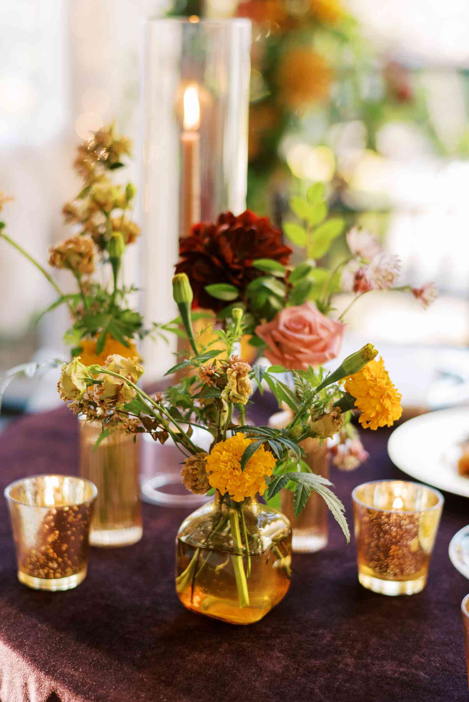 Red and Yellow Flower Decor in Bud Vases With Small Candles on Purple Linens