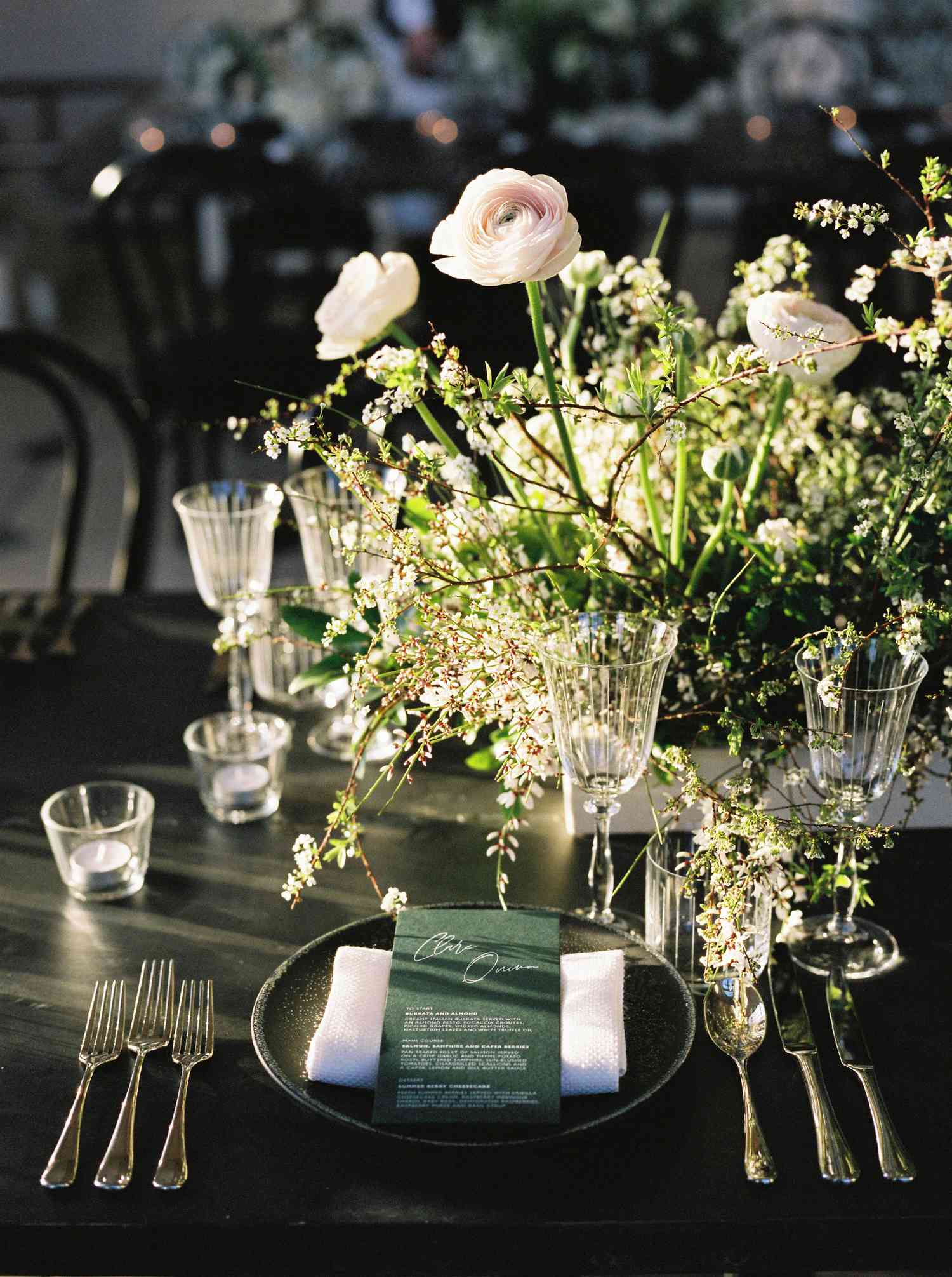 reception place setting with black charger and emerald green menu card