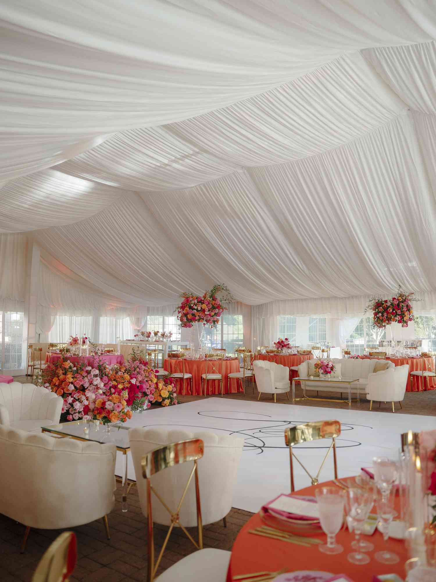 White and Orange Decor at Wedding Venue with draping on ceiling and walls