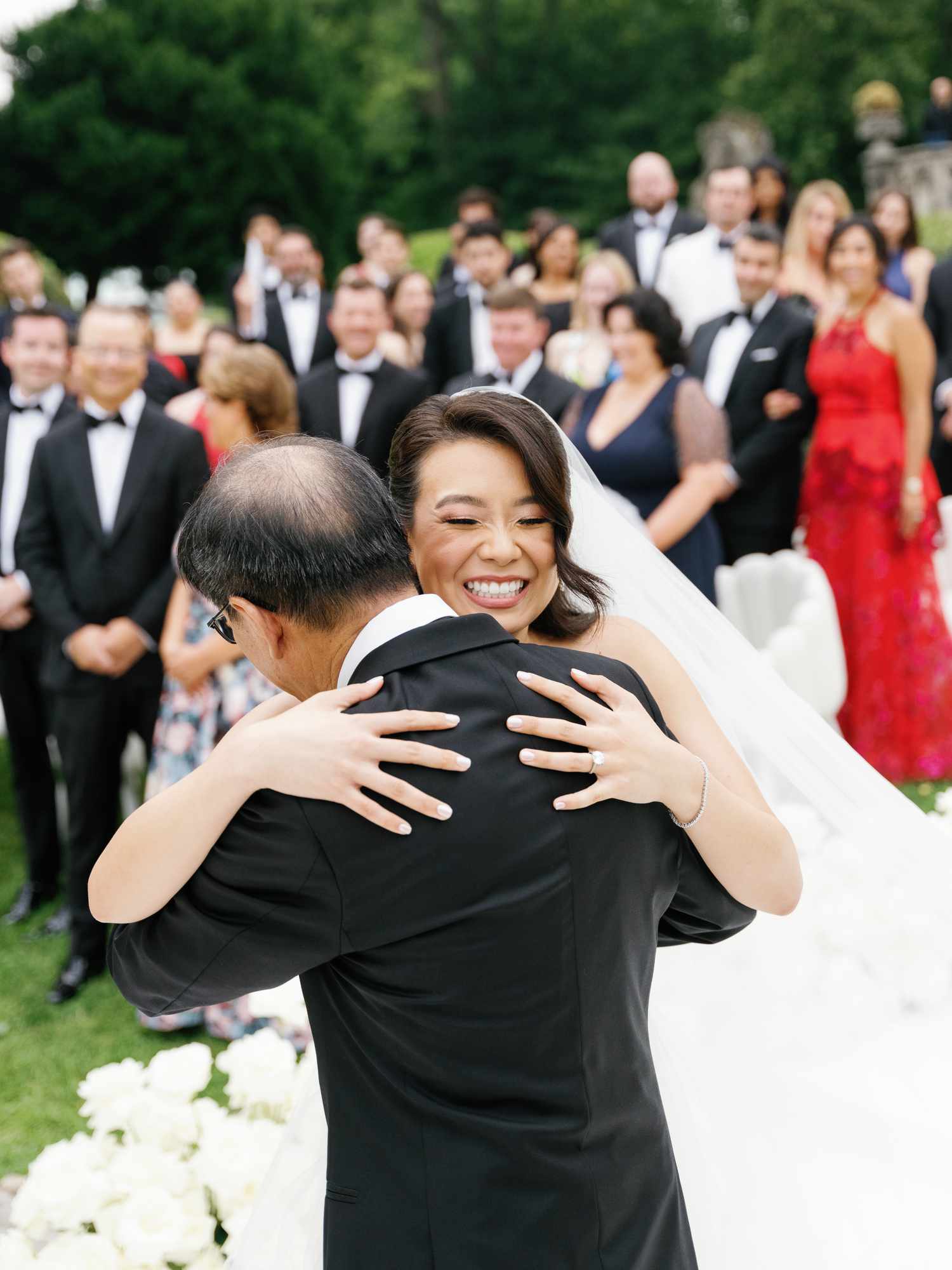 Bride in Wedding Dress and Veil Hugging Father in Black Tuxedo in Aisle