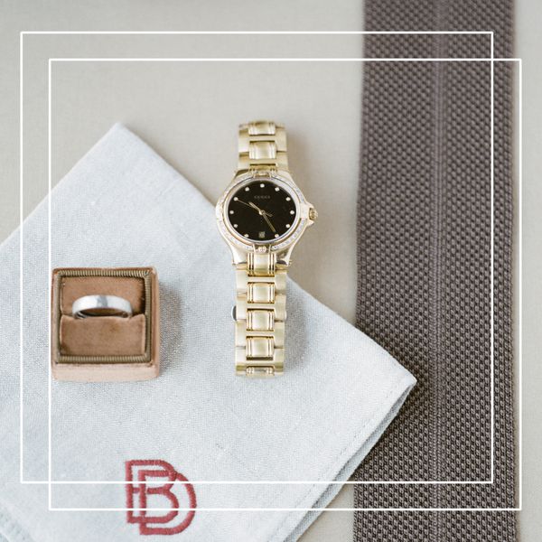 A man's watch next to a wedding band