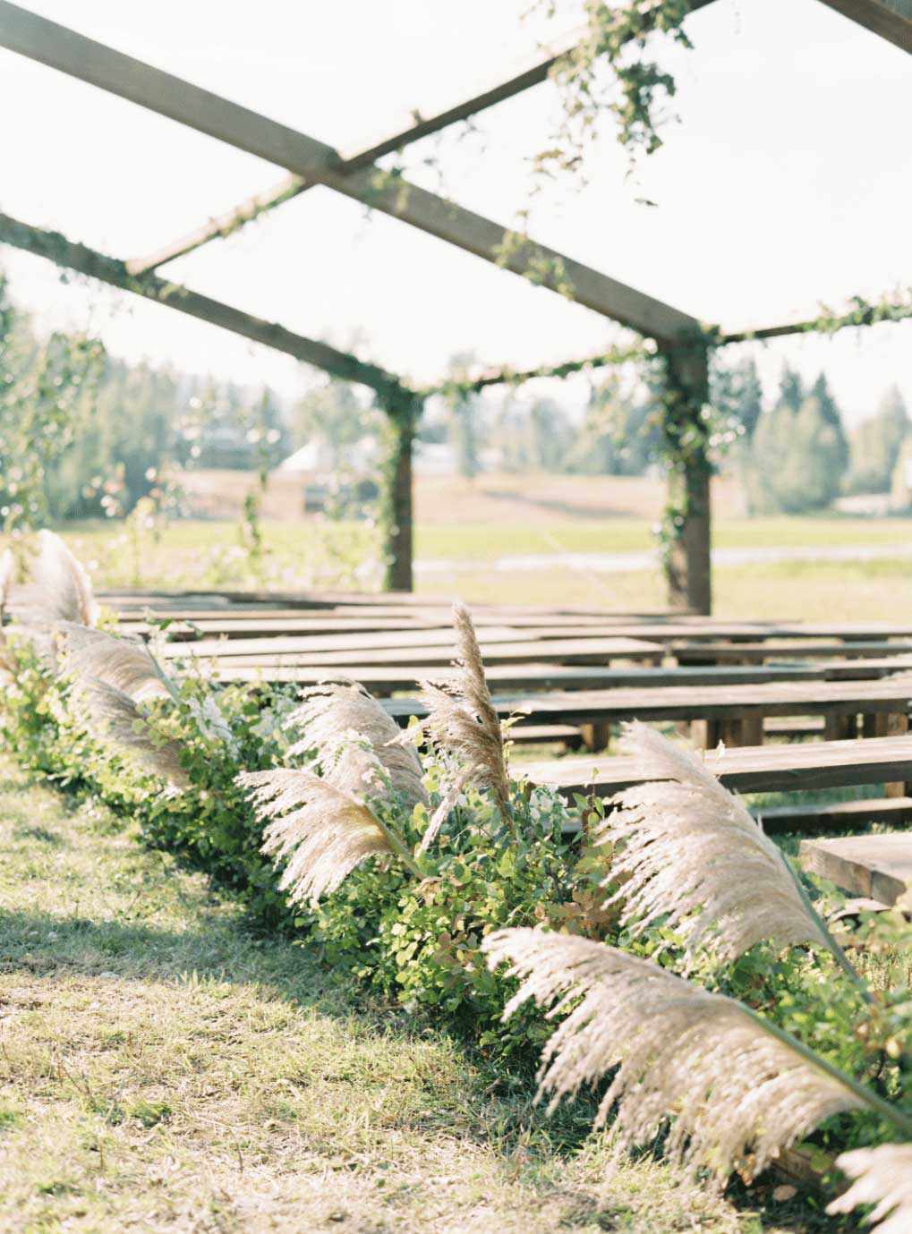 Altar in rustic open air chapel with aisle runners of greenery and dried grasses