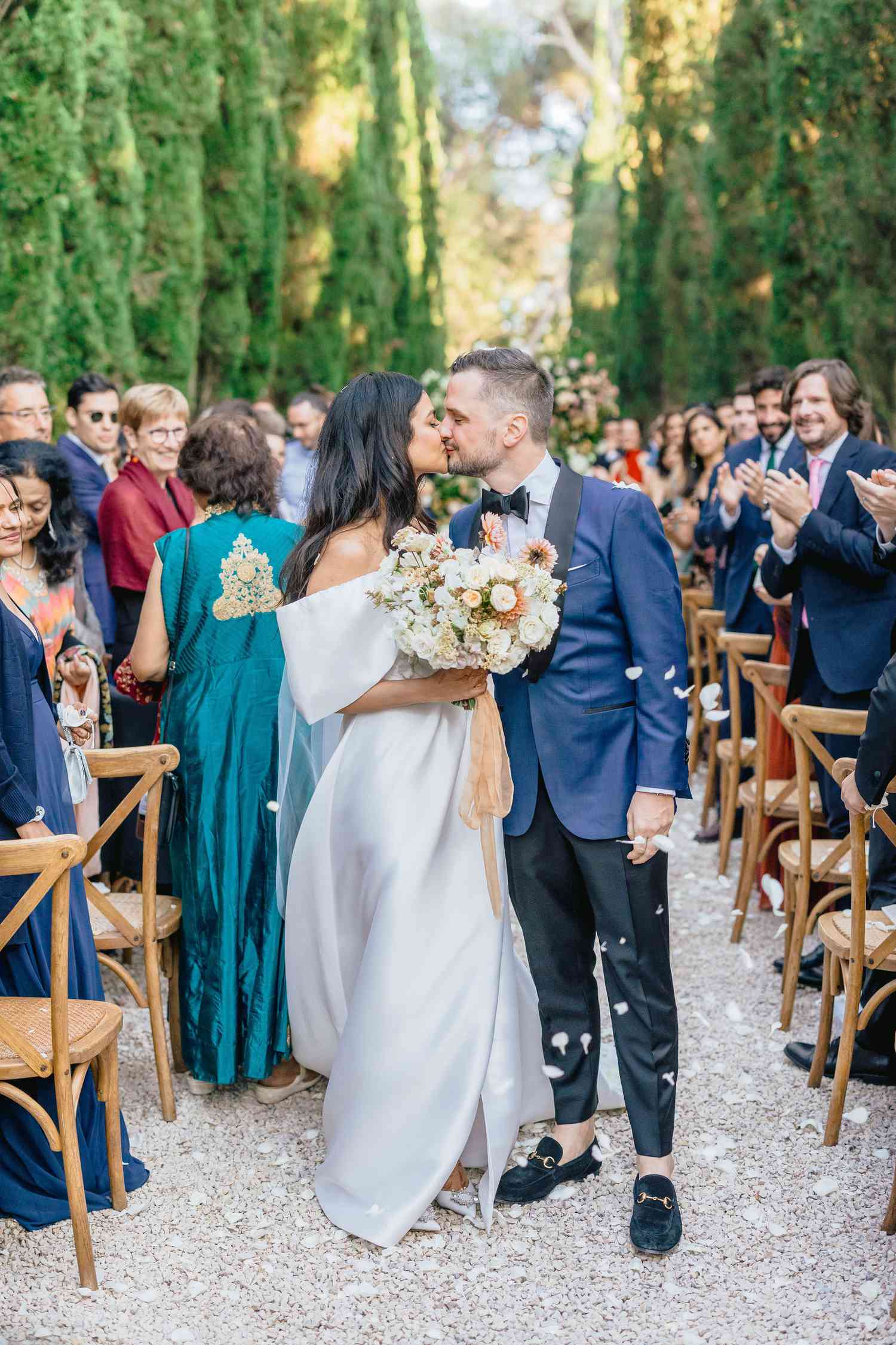 bride and groom kissing in middle of the ceremony aisle