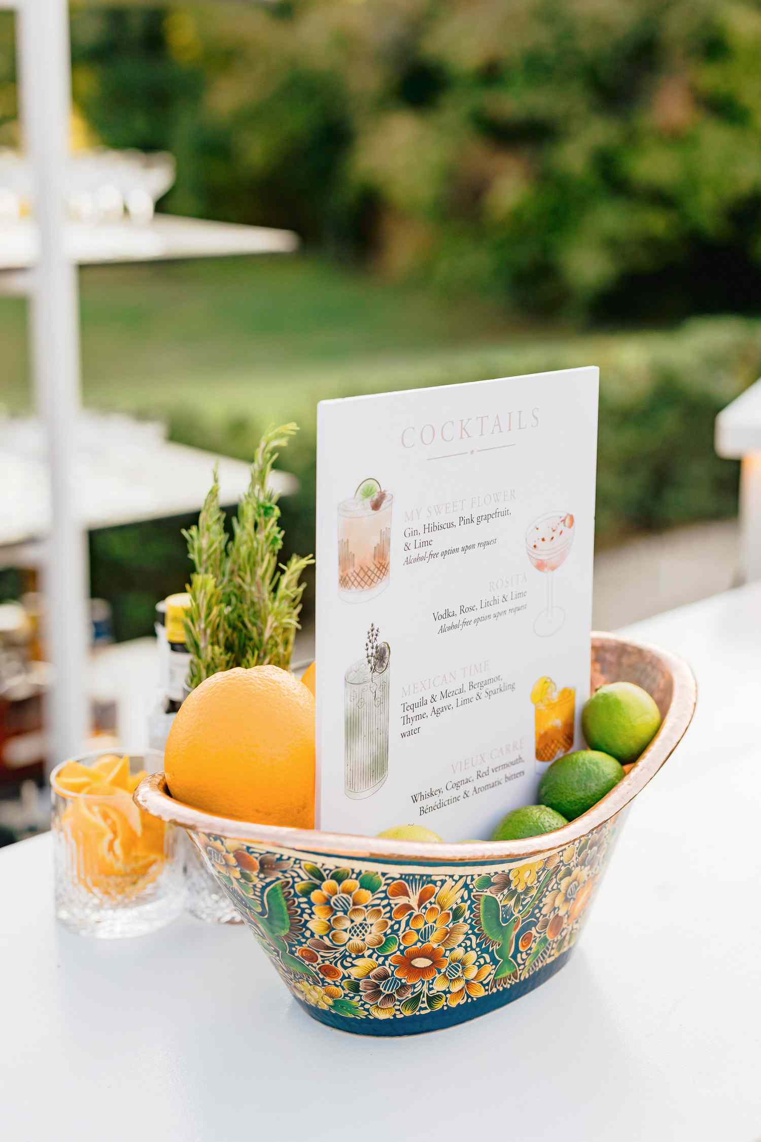 cocktail menu in a bowl of oranges and limes