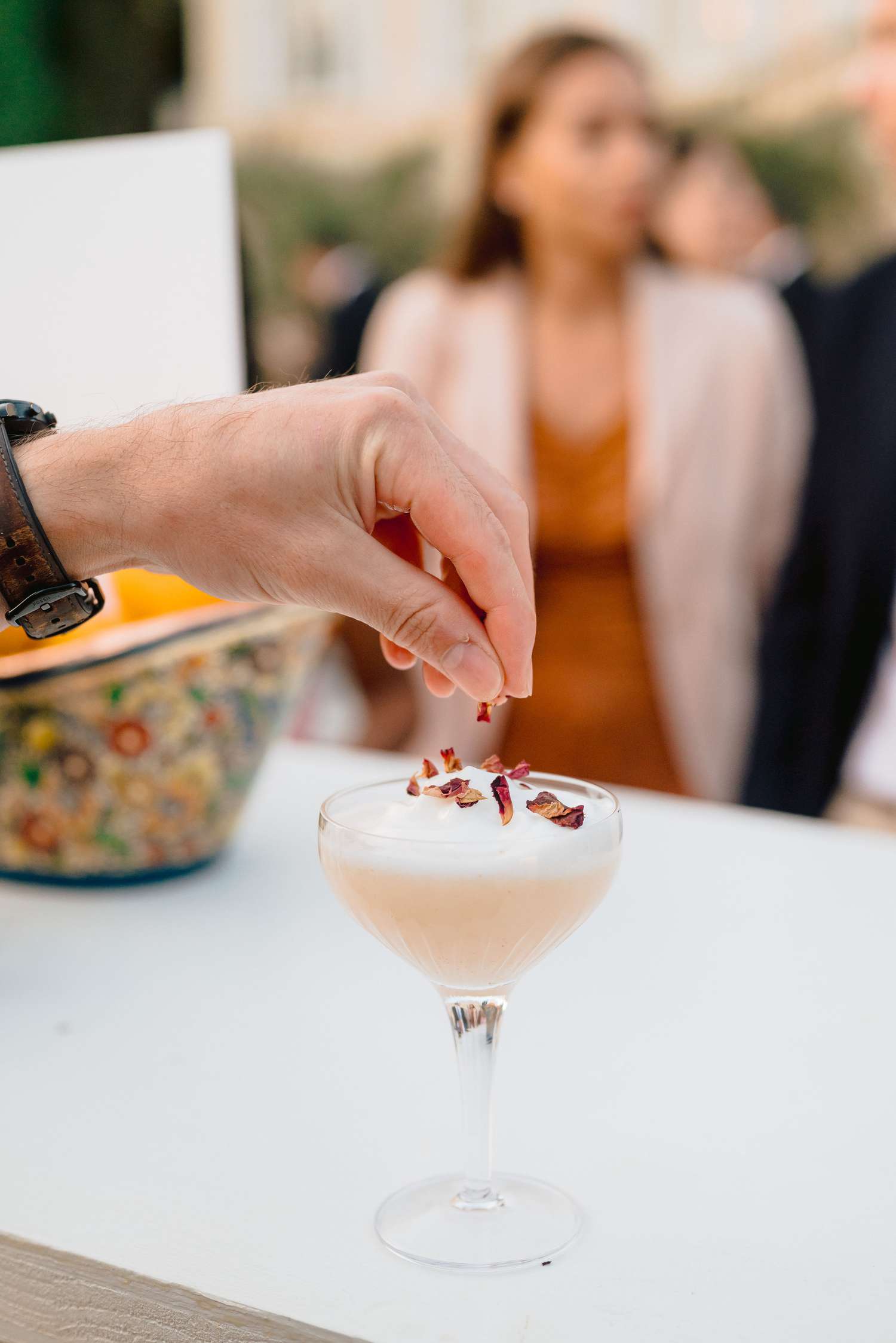 bartender adding garnish petals on a cocktail