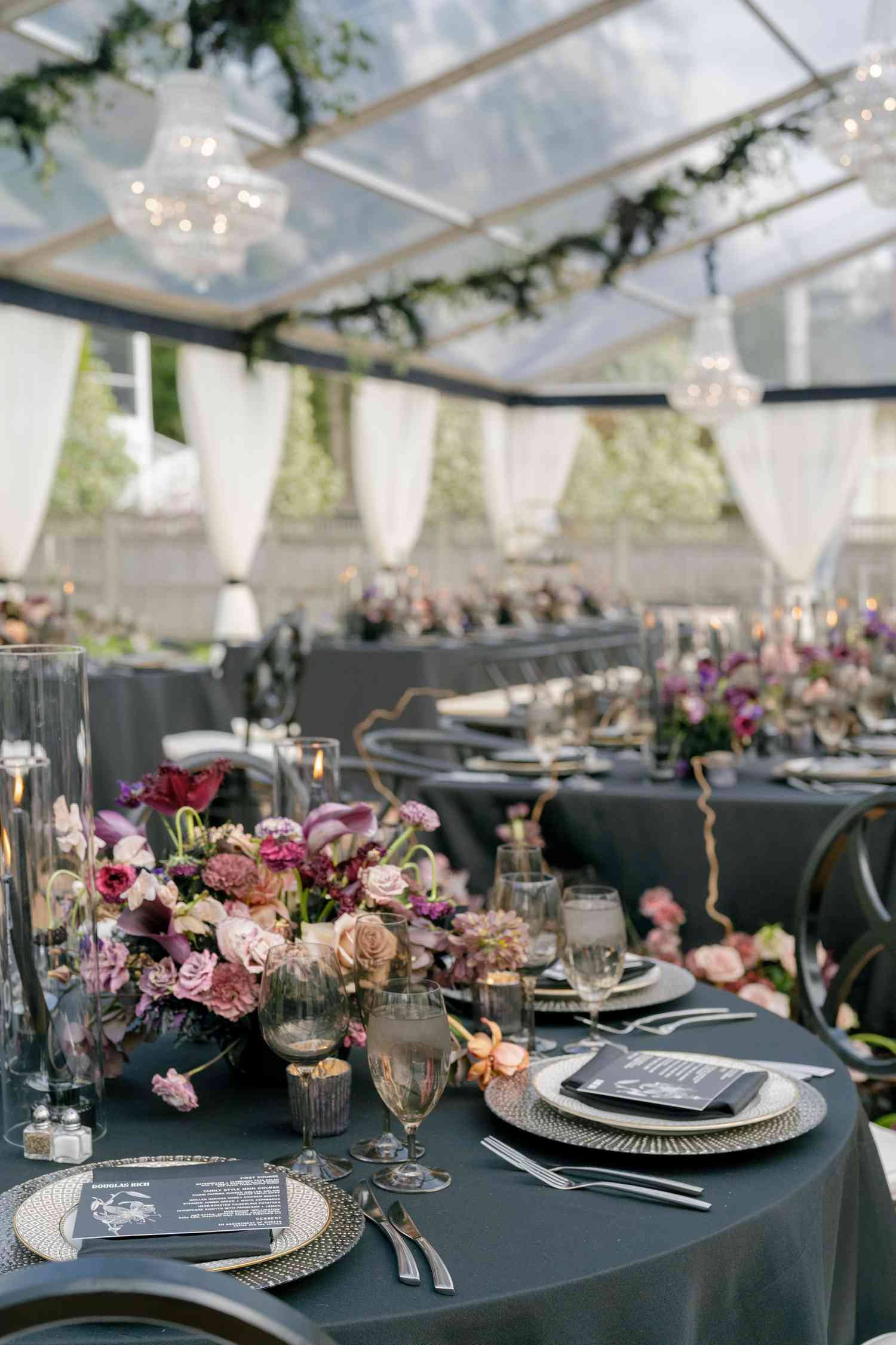Black Reception Tables With Dark Flower Decor and Chandeliers Under Glass Tent