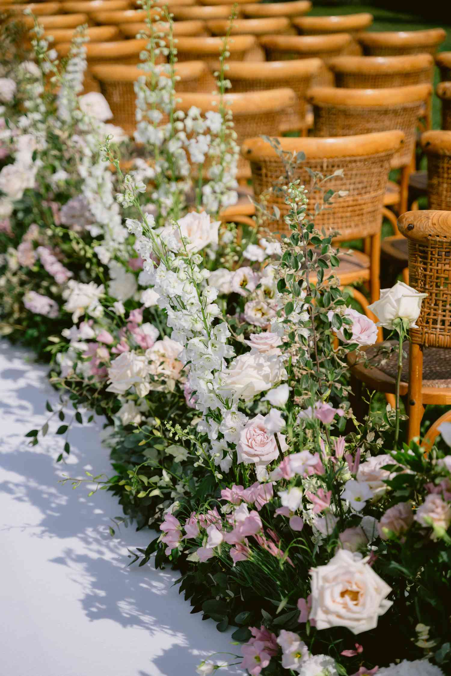 Pink and White Flower Decor Along Aisle Next to Rattan Chairs