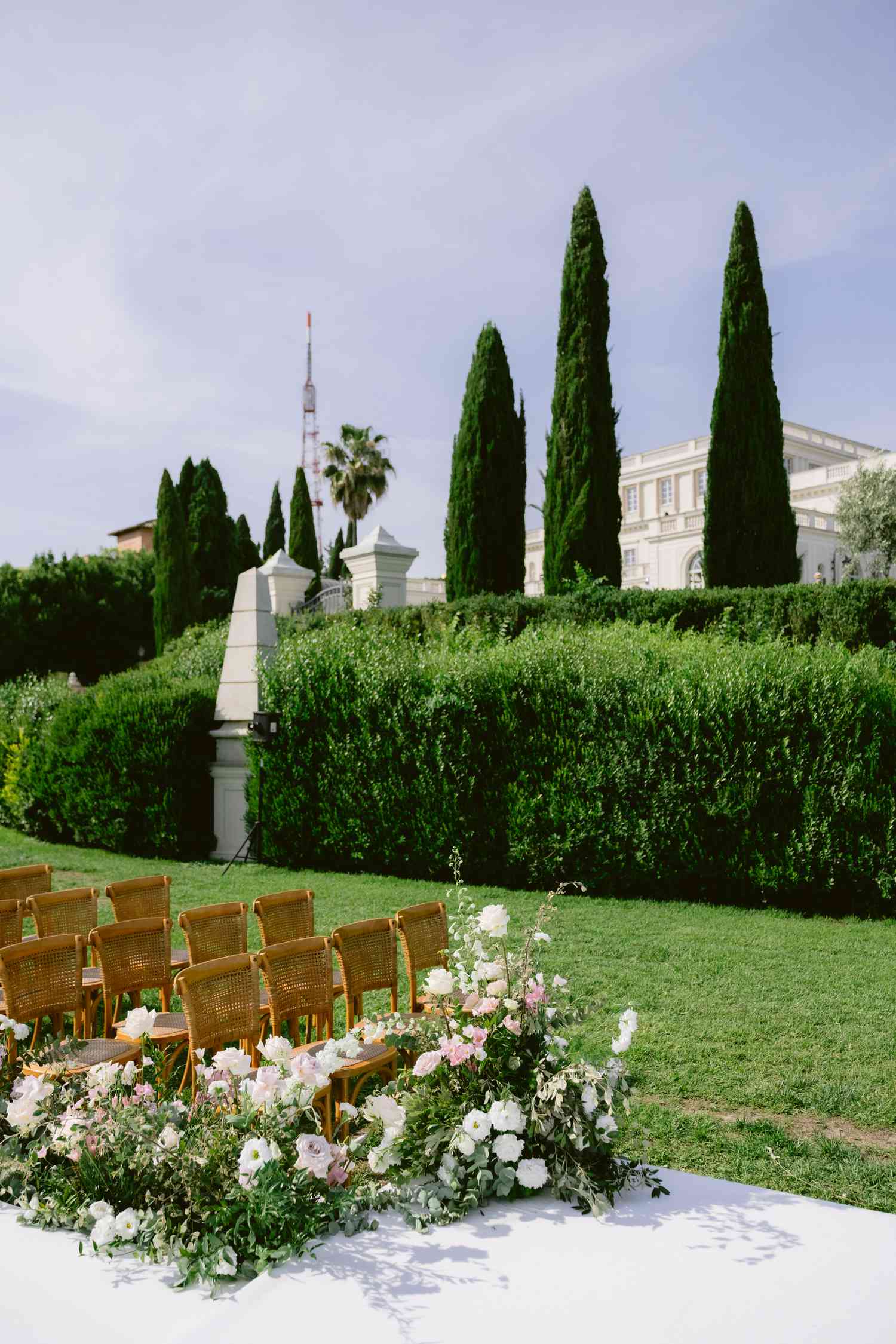 Pink and White Flower Decor Next to Rattan Chairs at Wedding Ceremony