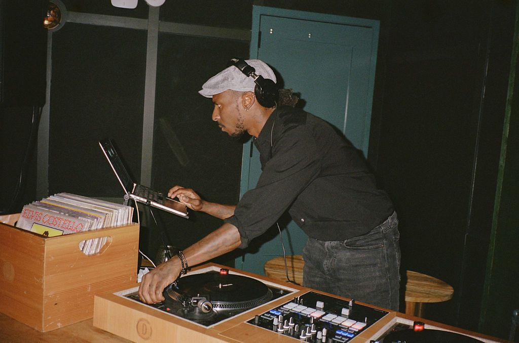 DJ In Black Attire With Box of Records at Wedding Reception