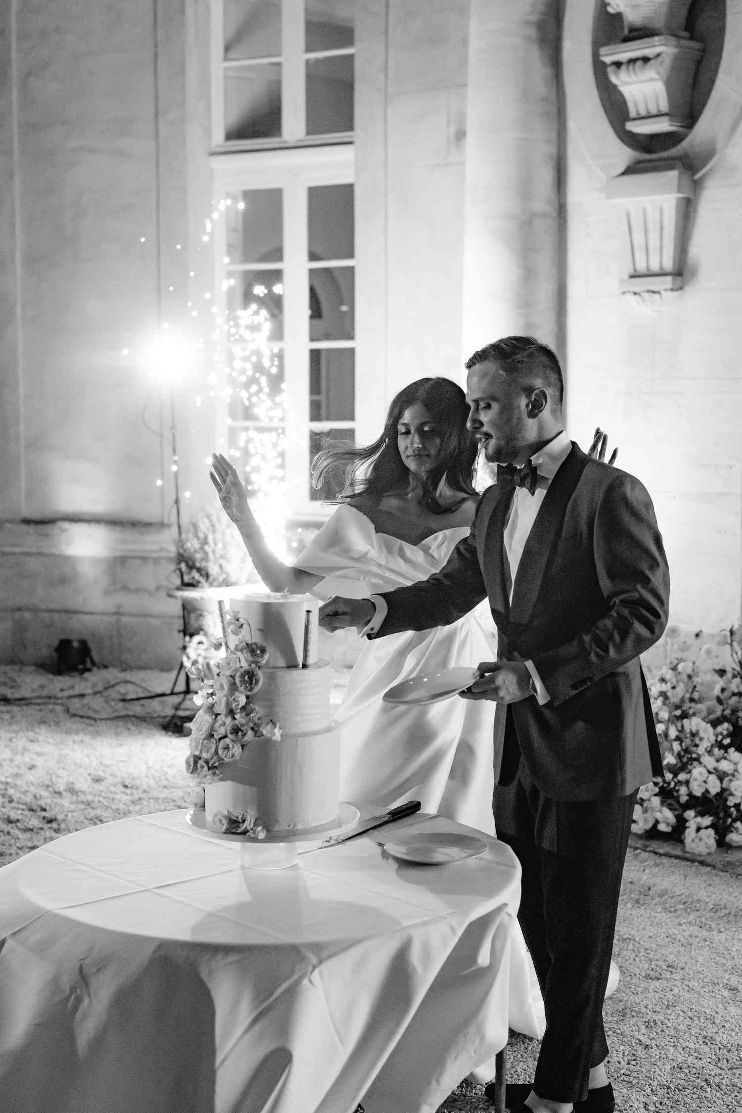 bride and groom cutting cake with sparklers