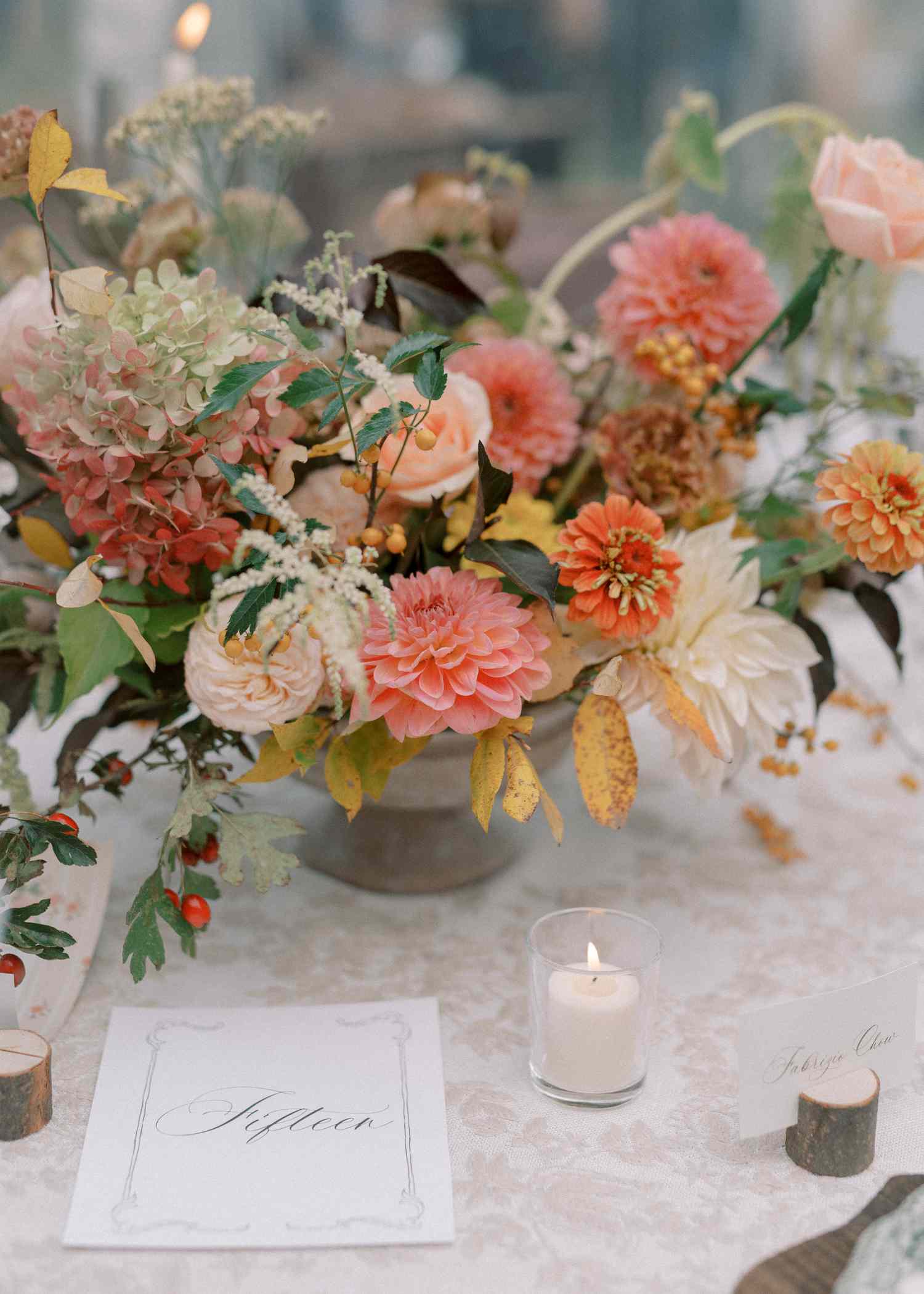 Colorful Flower Decor Next to Small Candle and Table Number at Reception Table