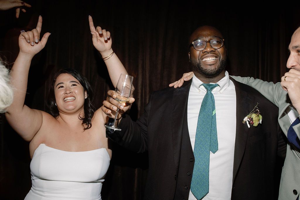 Bride in Strapless Wedding Dress Dancing With Groom in Black Tuxedo With Teal Tie
