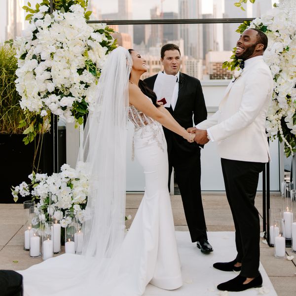 bride and groom holding hands during wedding ceremony on rooftop
